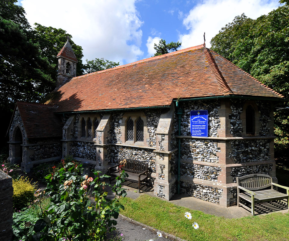 Flint and stone built church with benches and plating around