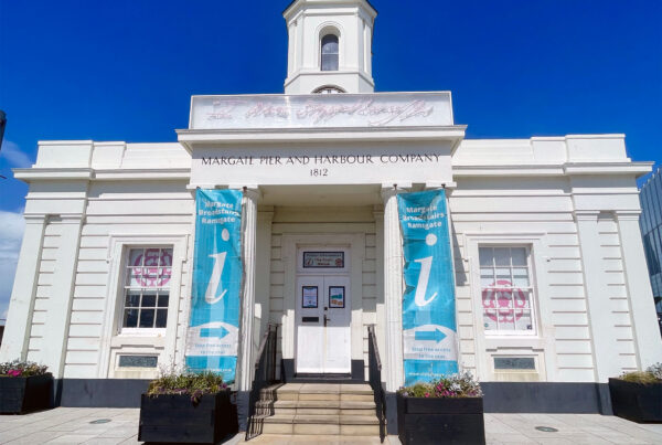 Entrance to The Droit House visitor information centre in Margate, featuring neon art and a clock tower.