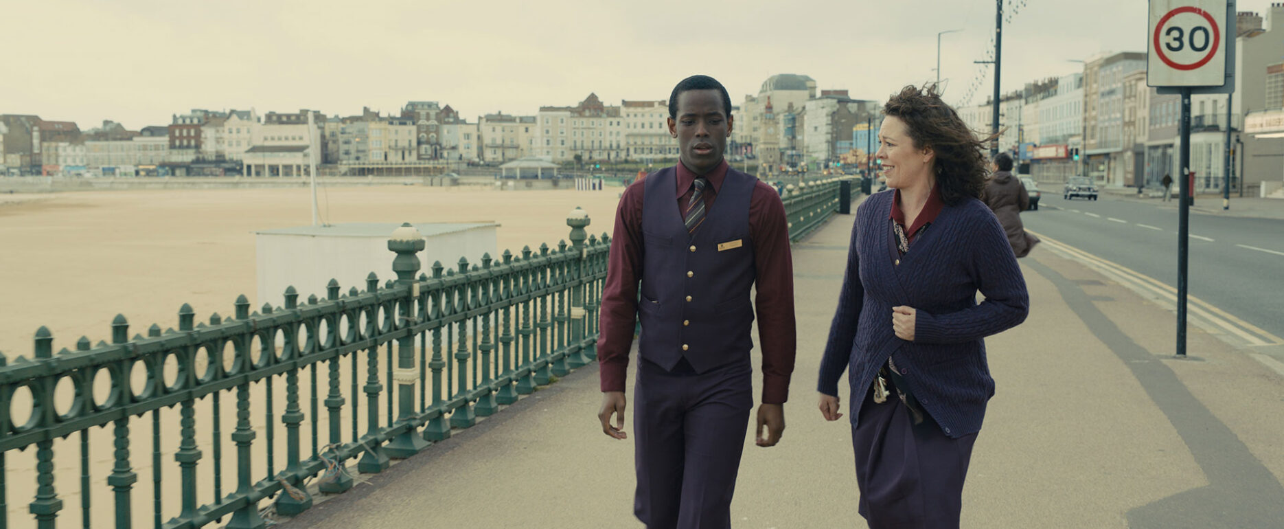 Film characters (man and lady) walking along promenade by beach