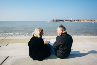 Couple-eating-fish-and-chips-on-Kings-Steps-harbour-arm-in-background.-Credit-@VisitThanet