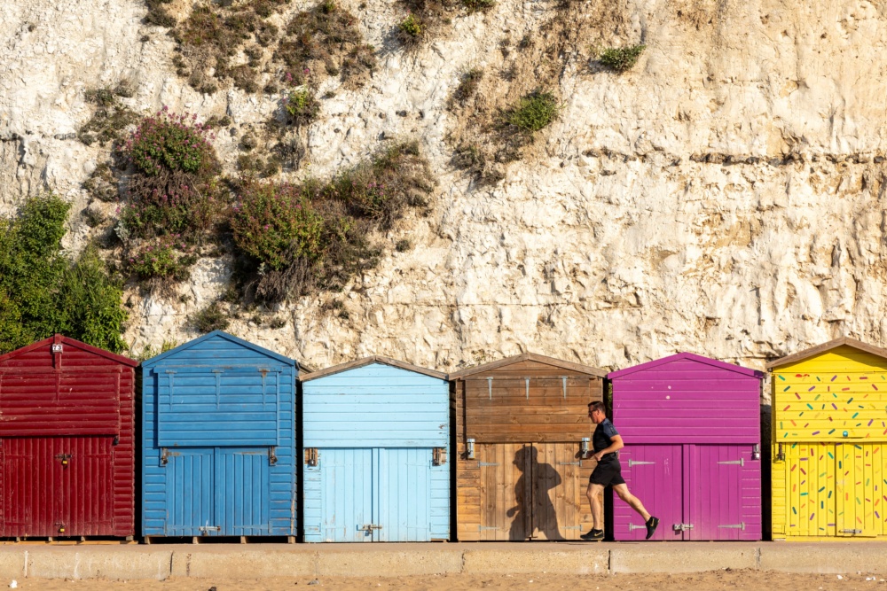 Running-past-beach-huts-at-Stone-Bay-Broadstairs.-Credit-@VisitThanet